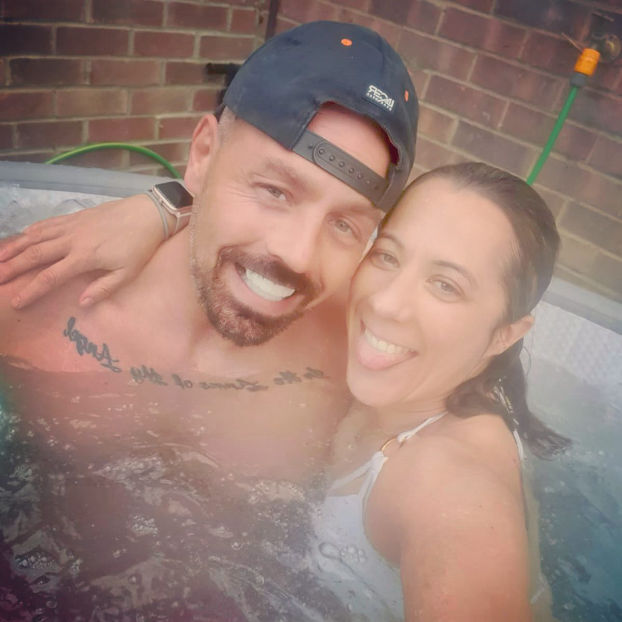 couple in hot tub with smiles